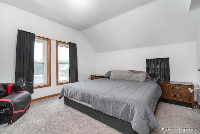 bedroom with lofted ceiling, carpet floors, and baseboards