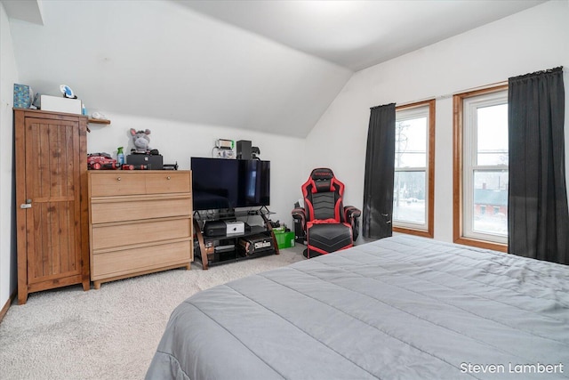 bedroom with lofted ceiling and light colored carpet