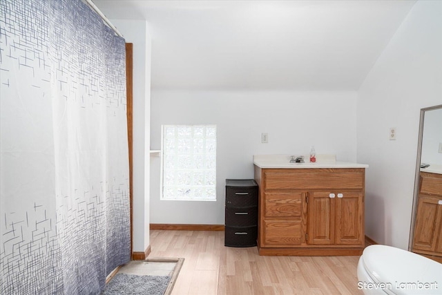 full bathroom featuring toilet, wood finished floors, vanity, and baseboards