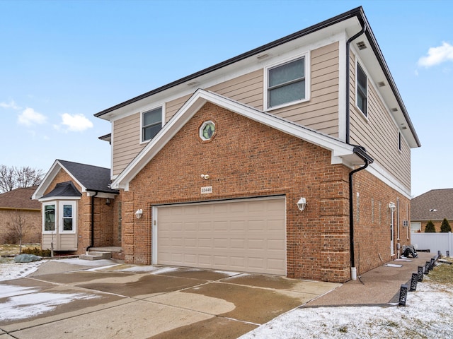 traditional-style home featuring an attached garage, concrete driveway, and brick siding