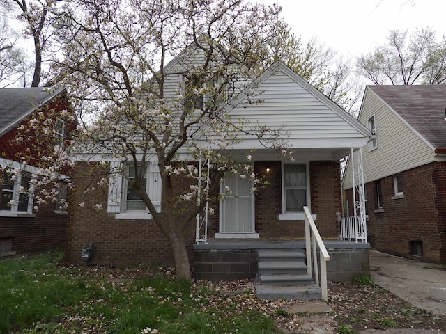 view of front of house featuring covered porch and brick siding