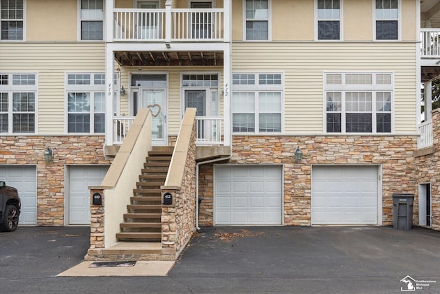 view of exterior entry with stone siding and driveway