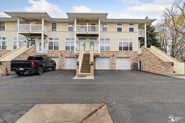 view of front facade featuring driveway, stairway, and an attached garage