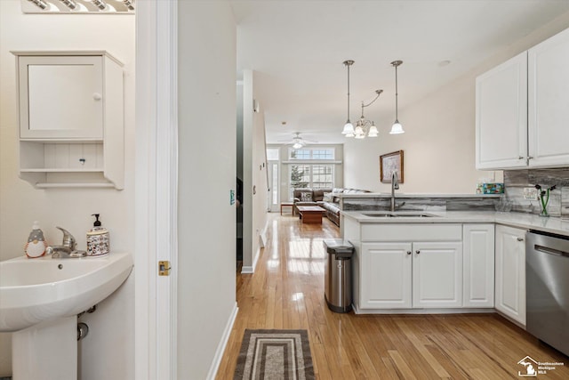 kitchen featuring dishwasher, white cabinetry, light wood-style floors, and a sink