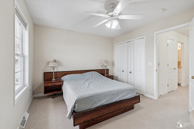 bedroom with light carpet, a closet, visible vents, and baseboards