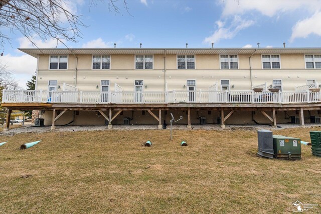 rear view of house with a deck, a lawn, and central air condition unit