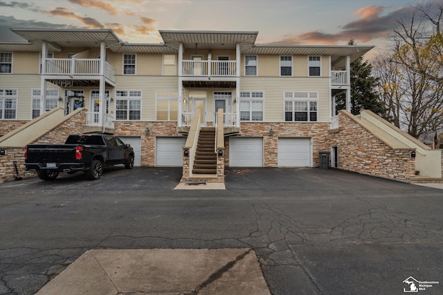 view of front facade featuring driveway, an attached garage, and stairs