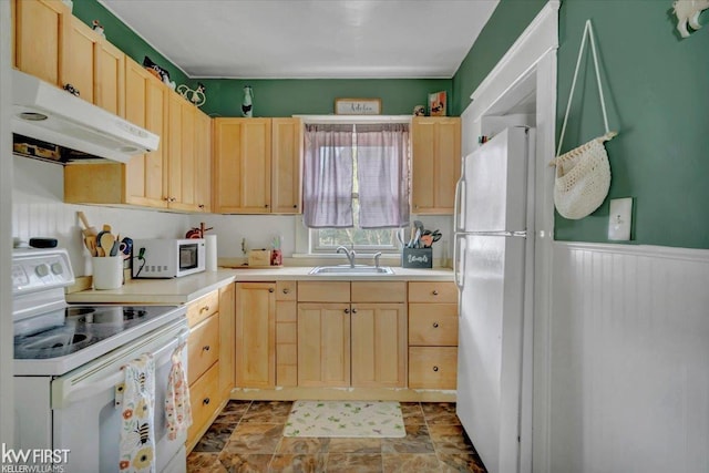 kitchen featuring white appliances, light brown cabinets, and under cabinet range hood