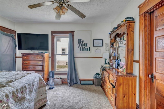 carpeted bedroom with ceiling fan and a textured ceiling