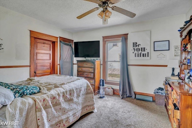 carpeted bedroom with a ceiling fan and a textured ceiling