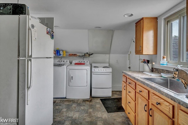 washroom with laundry area, washing machine and clothes dryer, a sink, and stone finish flooring