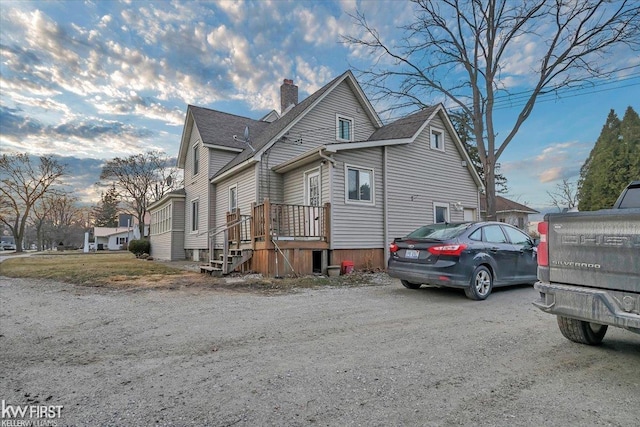 view of home's exterior with a shingled roof and a chimney