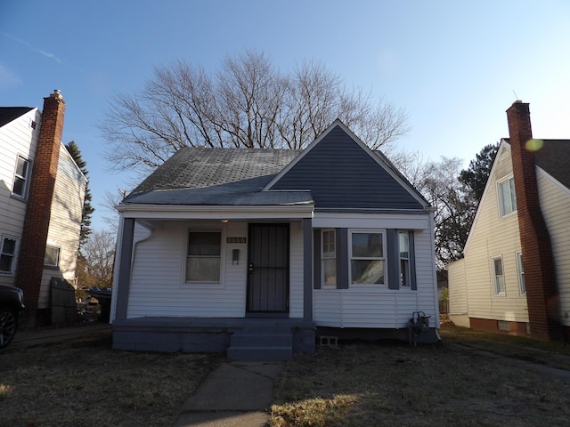 bungalow with covered porch and roof with shingles