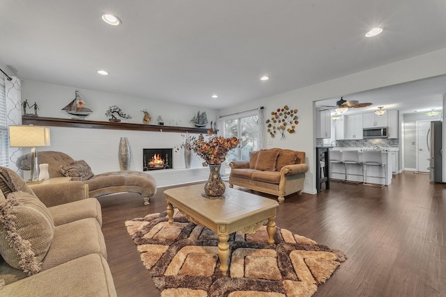 living area with dark wood finished floors, recessed lighting, and a fireplace