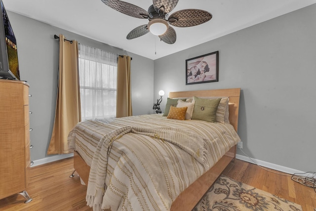 bedroom featuring a ceiling fan, wood finished floors, and baseboards