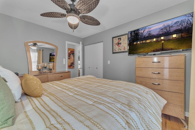 bedroom with wood finished floors, a ceiling fan, arched walkways, and a closet