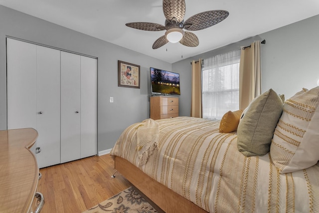 bedroom featuring a closet, baseboards, light wood-style flooring, and a ceiling fan