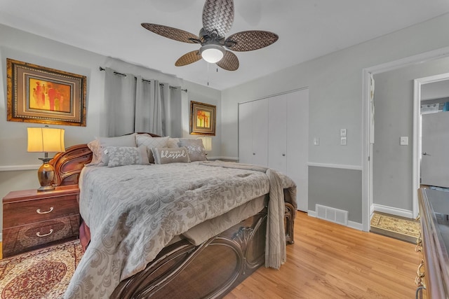 bedroom with visible vents, ceiling fan, baseboards, light wood-type flooring, and a closet