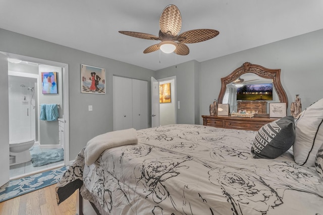 bedroom featuring a ceiling fan, baseboards, wood finished floors, a closet, and connected bathroom