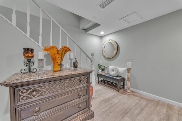 hallway with light wood-type flooring, visible vents, recessed lighting, baseboards, and stairs