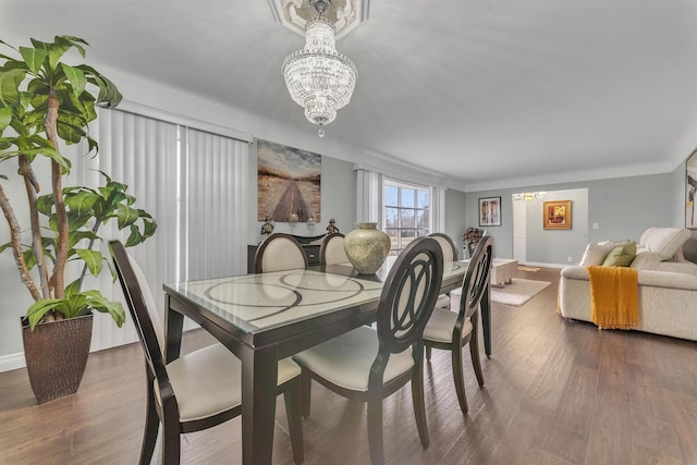 dining room featuring baseboards, wood finished floors, and a chandelier