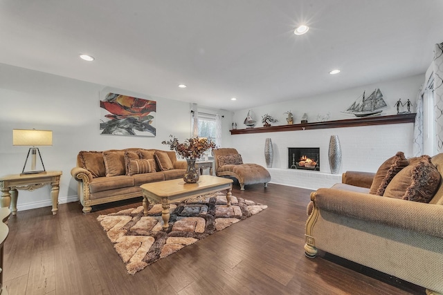 living room featuring recessed lighting, a brick fireplace, and wood-type flooring