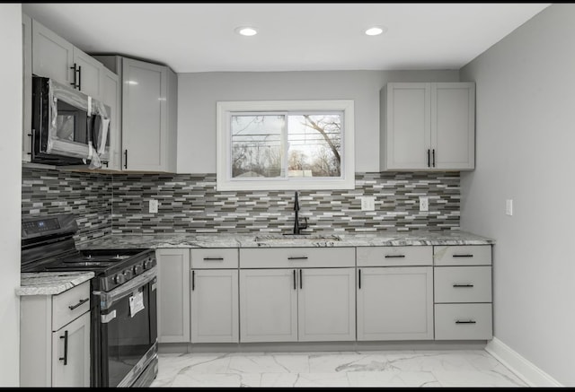 kitchen featuring stainless steel appliances, a sink, marble finish floor, gray cabinets, and tasteful backsplash