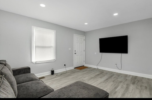 living room with visible vents, baseboards, wood finished floors, and recessed lighting