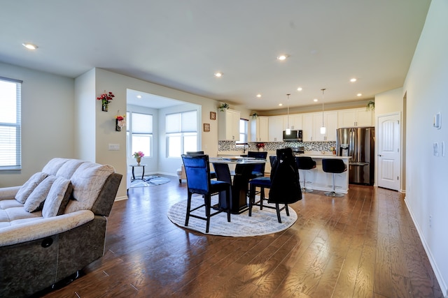 dining room featuring dark wood-type flooring, recessed lighting, and baseboards