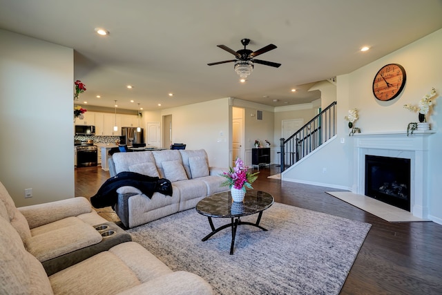 living room featuring dark wood-type flooring, recessed lighting, stairway, a fireplace, and baseboards