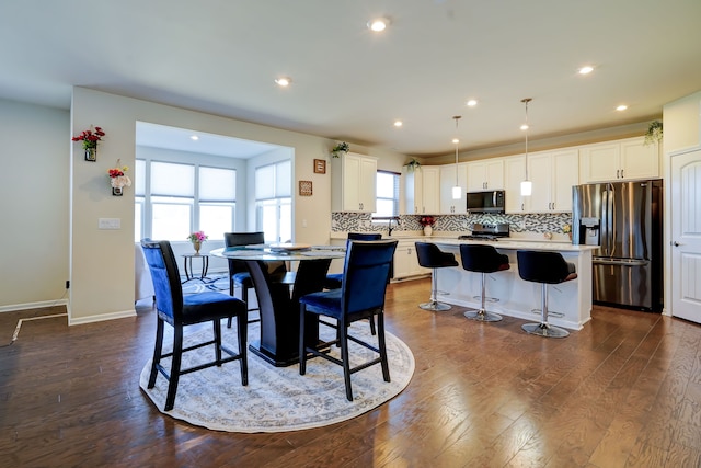 dining room featuring dark wood-type flooring, recessed lighting, and baseboards