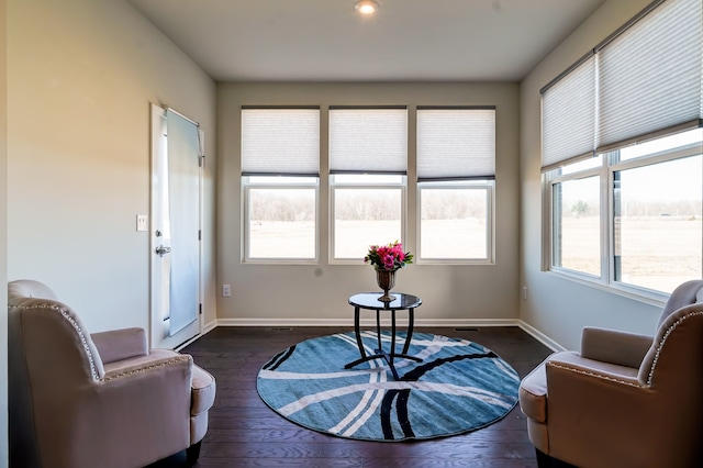 sitting room with dark wood finished floors and baseboards