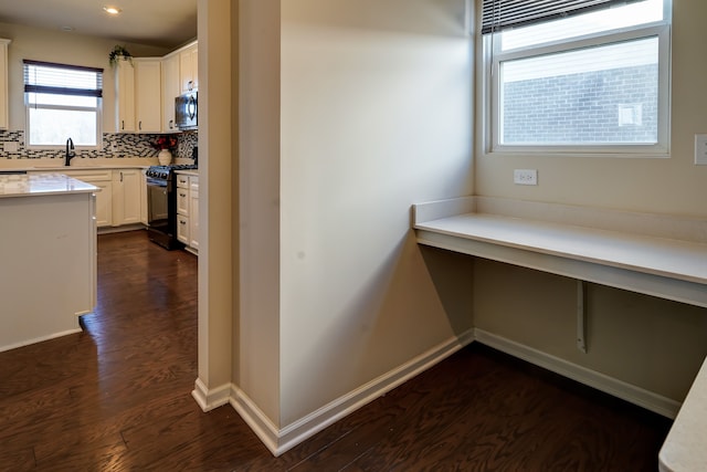 interior space with dark wood-type flooring, baseboards, and a sink