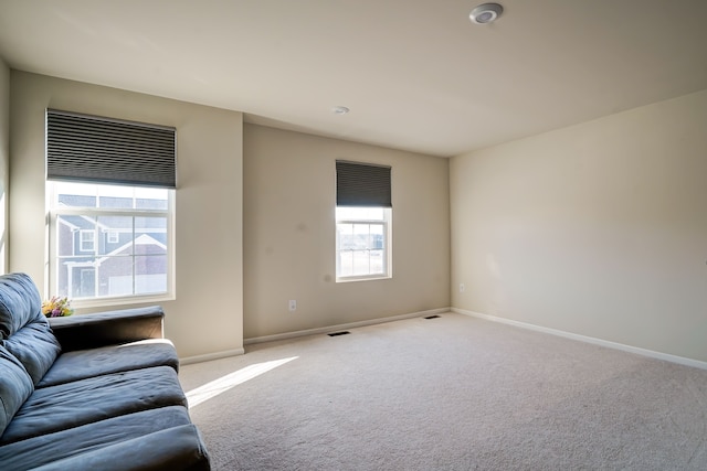 living room featuring visible vents, carpet, and baseboards