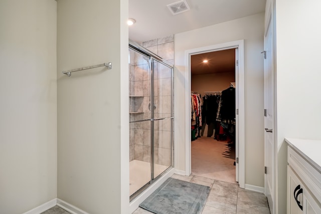 full bathroom featuring visible vents, a stall shower, tile patterned flooring, baseboards, and a spacious closet