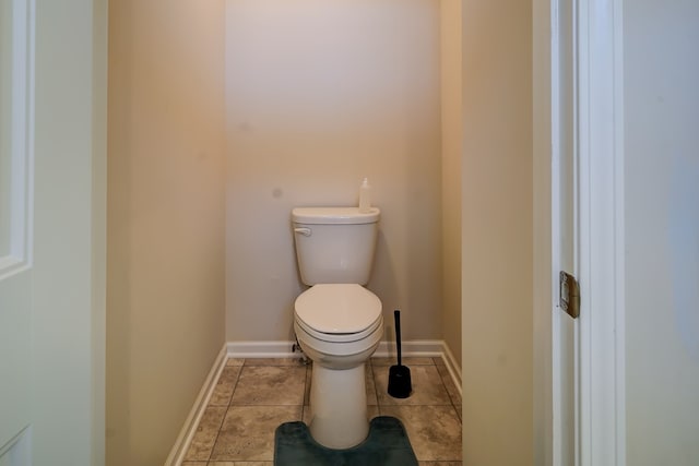 bathroom featuring tile patterned flooring, toilet, and baseboards