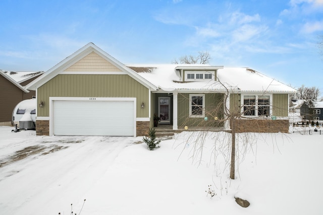 view of front of home with covered porch, stone siding, and an attached garage