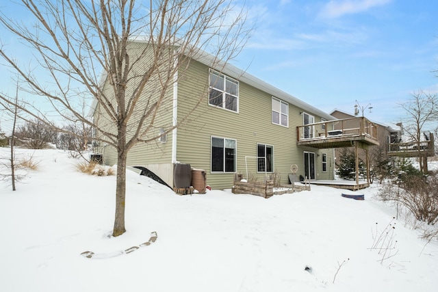 snow covered house with a wooden deck