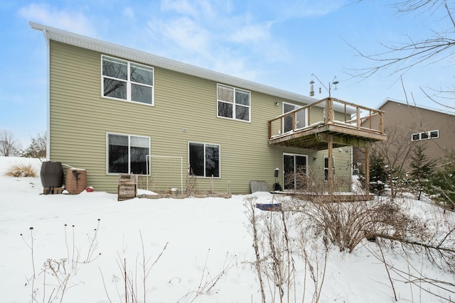 snow covered rear of property featuring a deck