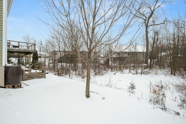 yard covered in snow with a deck