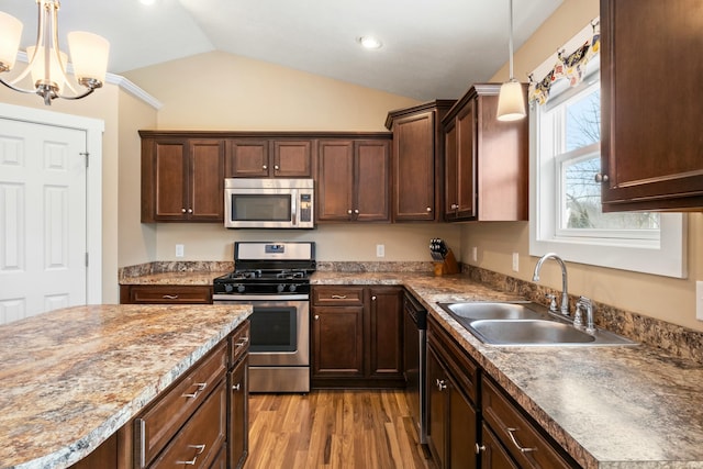 kitchen featuring wood finished floors, a sink, vaulted ceiling, dark brown cabinets, and appliances with stainless steel finishes