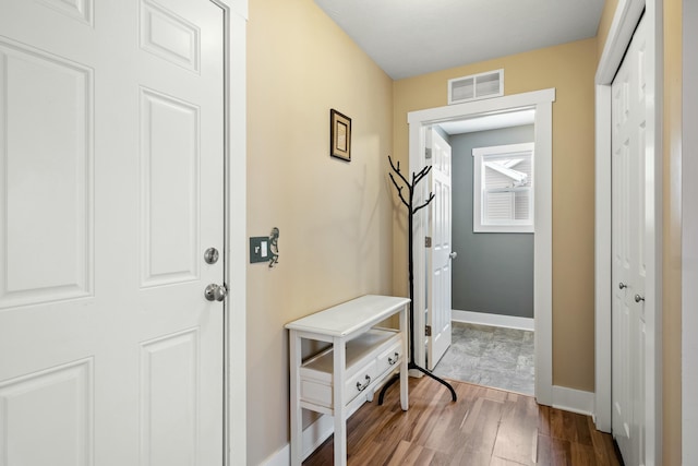 interior space with baseboards, visible vents, and dark wood-style flooring