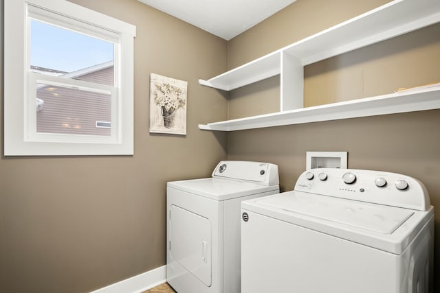 washroom with laundry area, baseboards, and washer and dryer