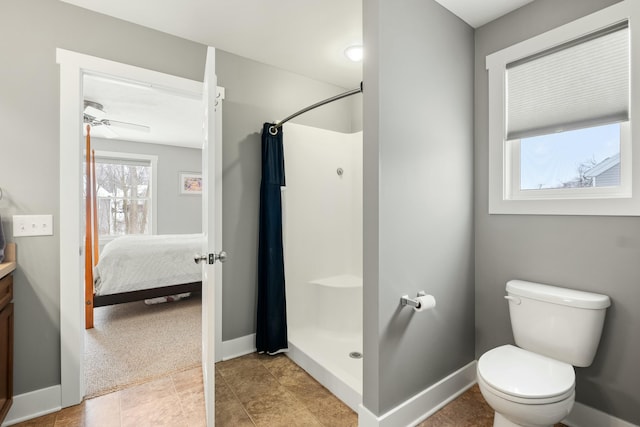 ensuite bathroom with curtained shower, baseboards, and toilet