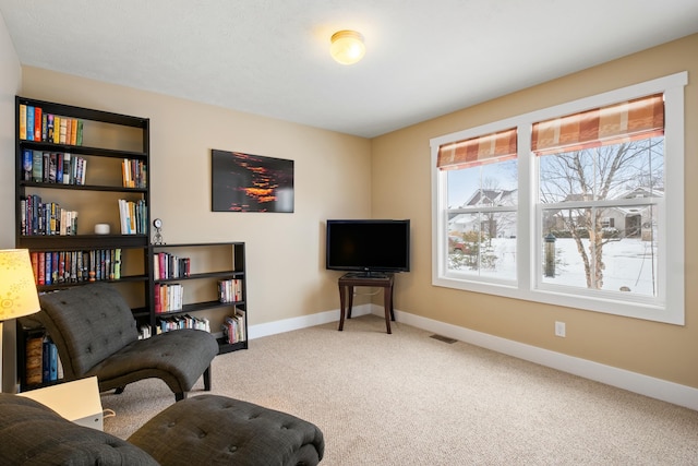 living area with carpet floors, visible vents, and baseboards