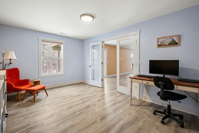 home office with visible vents, baseboards, wood finished floors, and french doors