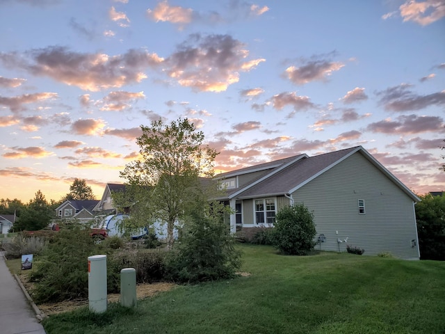 property exterior at dusk with a lawn