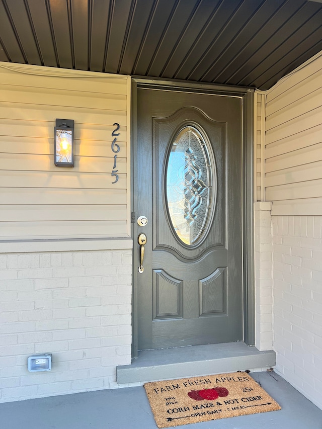 doorway to property with brick siding