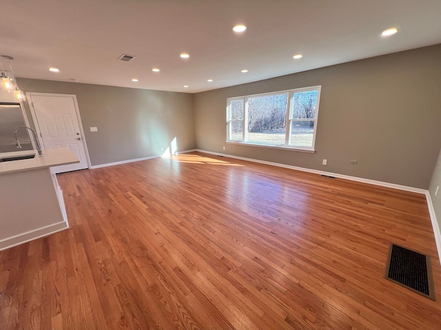 spare room with light wood-style floors, recessed lighting, visible vents, and baseboards