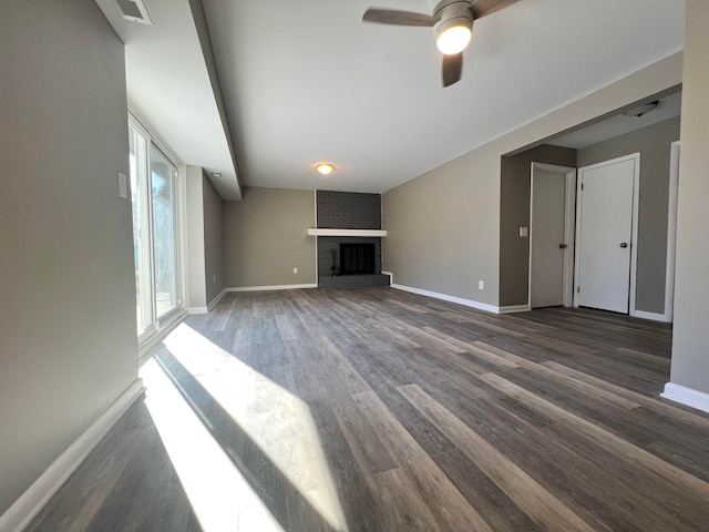 unfurnished living room with a ceiling fan, a fireplace, baseboards, and wood finished floors